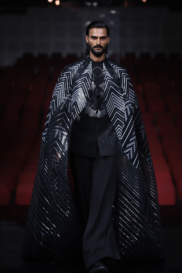 A man models a bold black and white ensemble at a fashion show in New Delhi, India.